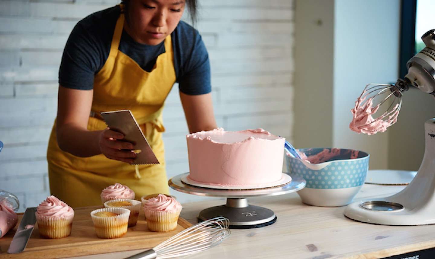 Home baker frosting a cake in a home kitchen